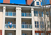 A woman stands on her balcony getting fresh air during isolation, Covid-19 world pandemic; St. Albert, Alberta, Canada