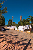 Straßenverkäufer auf einer Kopfsteinpflasterstraße, Torre de Manacas-Iznaga im Hintergrund, Valle de los Ingenios, Trinidad, Kuba, Westindien, Karibik