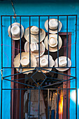 Close-up of straw hats displayed in doorway for sale, Trinidad, Cuba, West Indies, Caribbean