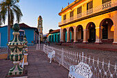 Weiße Metallstühle und Zaun vor dem Museo Romantico mit dem Turm des Klosters San Francisco im Hintergrund, Trinidad, Kuba, Westindische Inseln, Karibik