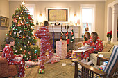 Familie beim Öffnen der Geschenke am Weihnachtsmorgen