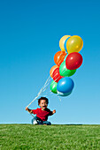 Weinender Junge mit Luftballons