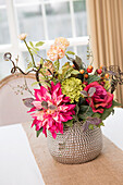 Floral centerpiece on table with burlap table runner