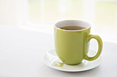 Cup of Tea in Green Mug with Saucer, Studio Shot