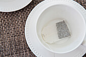 White porcelain teacups with unused tea bag, studio shot