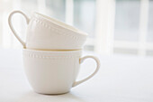 Gestapelte Teetassen aus weißem Porzellan, Atelieraufnahme
