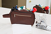 Herrentoiletten-Reisetasche auf dem Badezimmertisch, gefüllt mit Zahnbürste, Rasierschaum, Rasierapparat und anderen Pflegeprodukten, USA