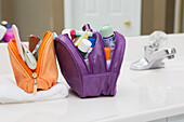 Damentoilettenreisetasche auf dem Badezimmertresen, gefüllt mit Körperpflegeprodukten