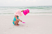 Toddler Girl Playing with Shovel and Bucket in Sand on Beach, Destin, Florida, USA