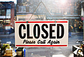 Closed Sign Hanging in Shop Window