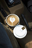 Zwei Kaffees mit Herzmotiv im Schaumstoff in Auto-Tassenhaltern