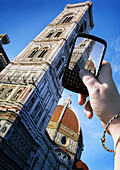Frauenhand beim Fotografieren der Basilica di Santa Maria del Fiore, Florenz, Italien
