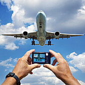 Hände halten Digitalkamera und fotografieren die Landung eines Jumbo-Jets auf dem Pearson International Airport, Toronto, Ontario, Kanada