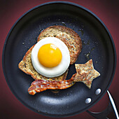 view of frying pan with bacon, egg and toast
