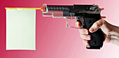 Close-up of woman's hand pointing toy gun on pink background, studio shot