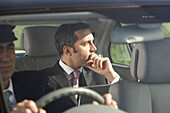 Businessman in Car With Chauffeur