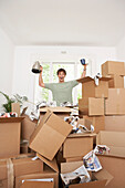 Man Finding Coffee Pot and Mugs in Boxes