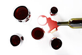 Rotweingläser mit verschütteter Flasche