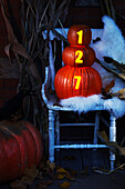 Für Halloween geschmückte Veranda mit Stuhl und Kürbissen mit beleuchteter Hausnummer, Toronto, Ontario, Kanada