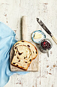 Draufsicht auf eine Scheibe Zimtrindenbrot mit Butter und Marmelade, Studioaufnahme