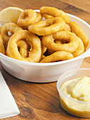 Fried calamari in bowl with condiment