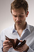 Mann schaut in leere Brieftasche