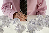 Businessman Surrounded by Crumpled Paper