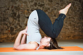 Woman in Yoga Class Doing Shoulder Stand