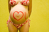 Pregnant Woman With I Love You Painted on Her Belly