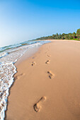 Fußabdrücke im Sand am Strand mit blauem Himmel, Indischer Ozean, Bentota, Galle District, Südprovinz, Sri Lanka