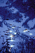 Übersicht von Häusern und Bäumen vom Berg aus bei Nacht im Winter, Schweiz