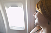 Frau schaut aus dem Flugzeugfenster