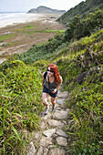 Woman Hiking up Coastal Hills, Ilha do Mel, Parana, Brazil