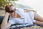 Frau am Strand liegend, Paraty, Costa Verde, Brasilien