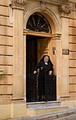 Ältere Nonne in Außentüröffnung
