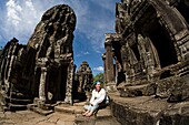 Tourist Outside Bayon Temple In Ancient City Of Angkor; Angkor Wat, Siem Reap, Cambodia