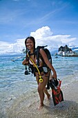 Junge Frau mit Tauchausrüstung im Wasser stehend; Dumaguete, Oriental Negros Island, Philippinen