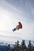 Man Snowboarding, Jumping In Mid-Air; Vancouver Island Ranges, British Columbia, Canada