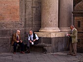Drei ältere Männer vor einer Hauswand auf der Piazza Del Plebiscito; Neapel, Italien