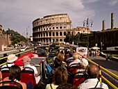 Gruppe von Touristen, die im Bus sitzen und das Kolosseum betrachten; Rom, Italien