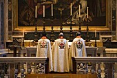 Drei Priester stehen am Altar im Petersdom; Vatikanstadt, Rom, Italien