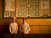 Zwei Männer vor einer Mauer stehend; Agra, Indien