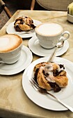 Two Cappucinos And Dessert On Table In Cafe; Verona, Italy