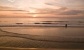 Paar genießt Sonnenuntergang am Strand in Kerala; Arabisches Meer, Kerala, Indien