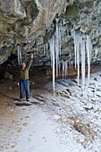 Ponytail Falls, Columbia River Gorge, Oregon, USA; Wanderer untersucht Höhleneiszapfen