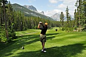 Mittelgroßer Mann beim Golfspielen; Canmore, Albertas Rockies, Alberta, Kanada