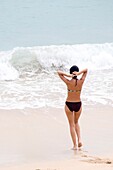 Young Woman Wearing Bikini Facing Sea Wave