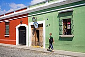 Antigua, Guatemala, Mittelamerika; Mann geht an einer Schule im Kolonialstil vorbei