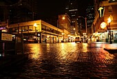 Pike Place Market, Seattle, Washington, USA; Lichter der Stadt spiegeln sich in der nassen Straße bei Nacht