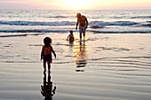 Puerto Vallarta, Mexiko; Vater am Strand mit Kindern bei Sonnenuntergang